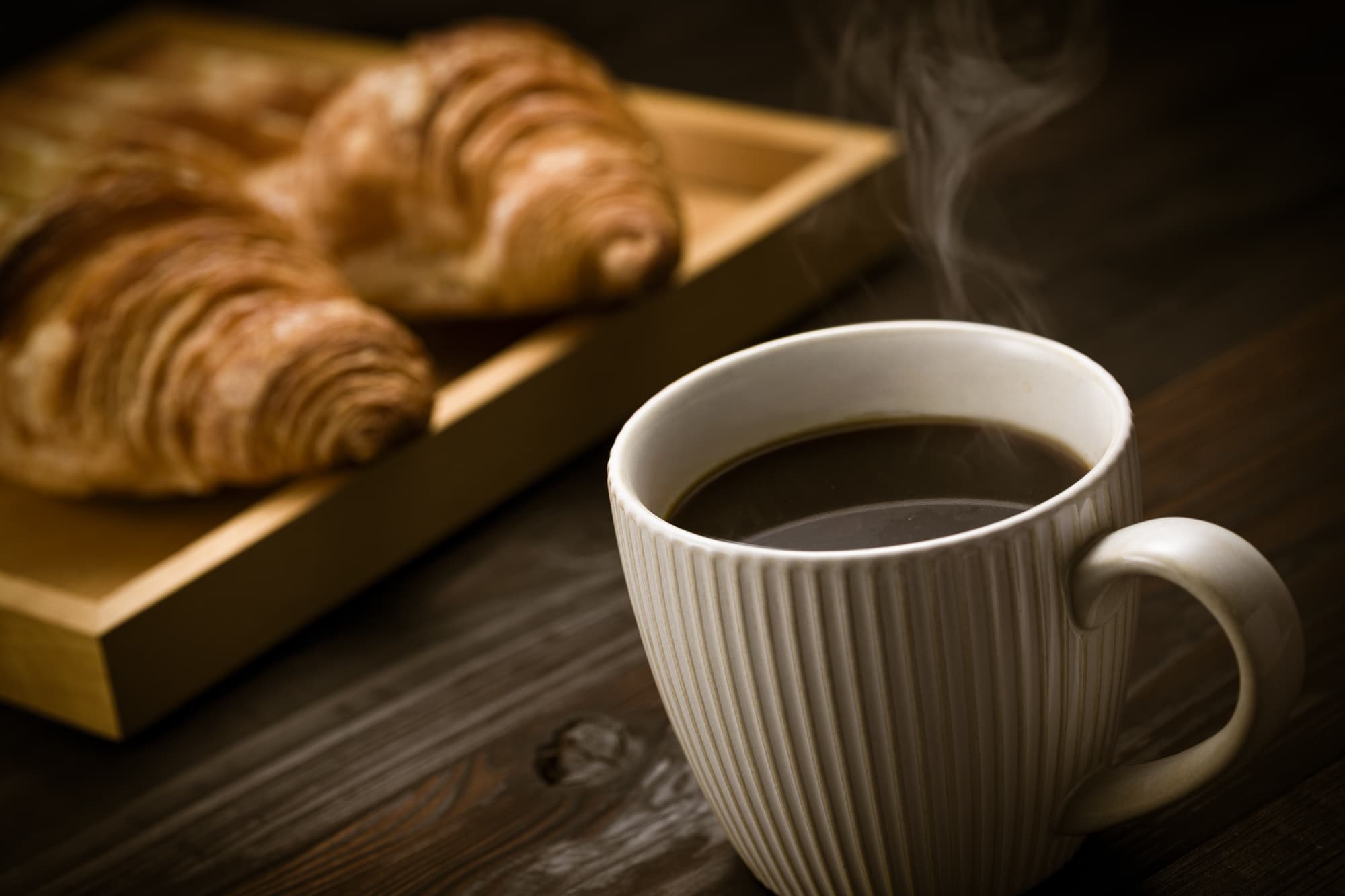 湯気の立つコーヒーとクロワッサン